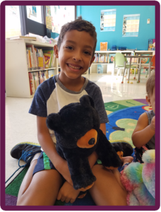 a boy holding a mini stuffed toy bear